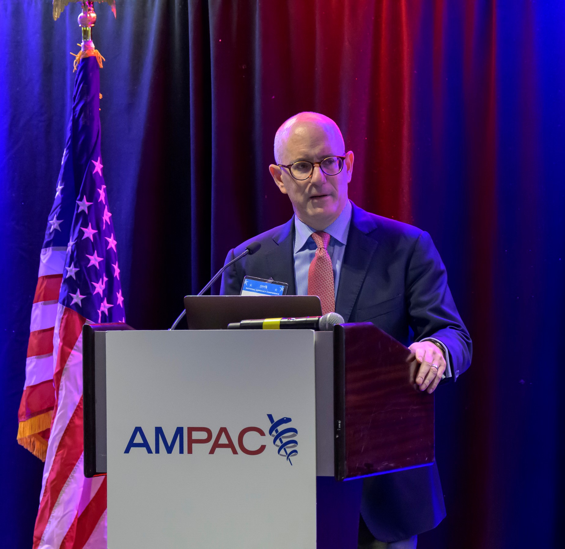 Rich Thau speaking at an AMPAC podium